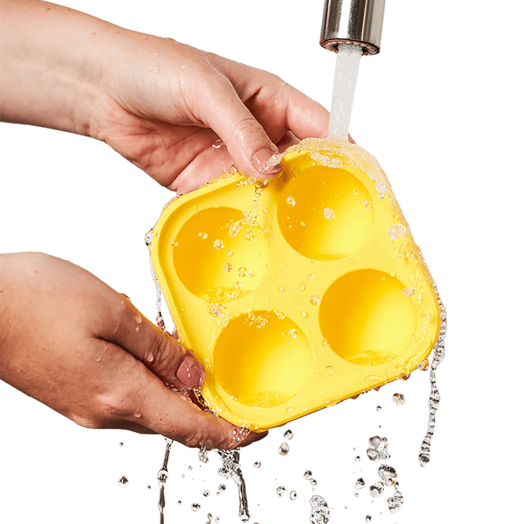 Person rinsing off the Pupsicle treat tray under running water.