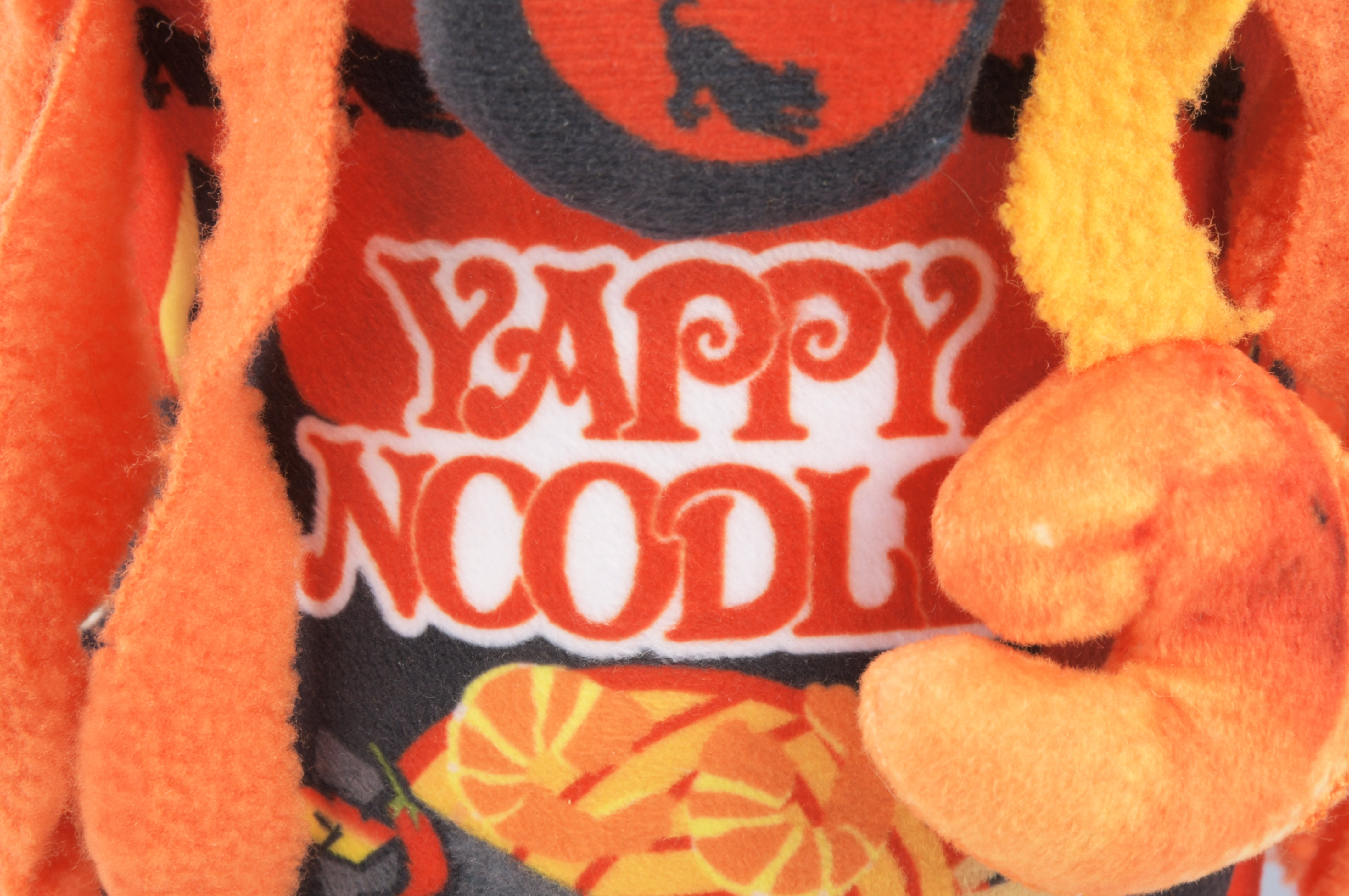 Close up view of a ramen noodle plush squeaky dog toy.