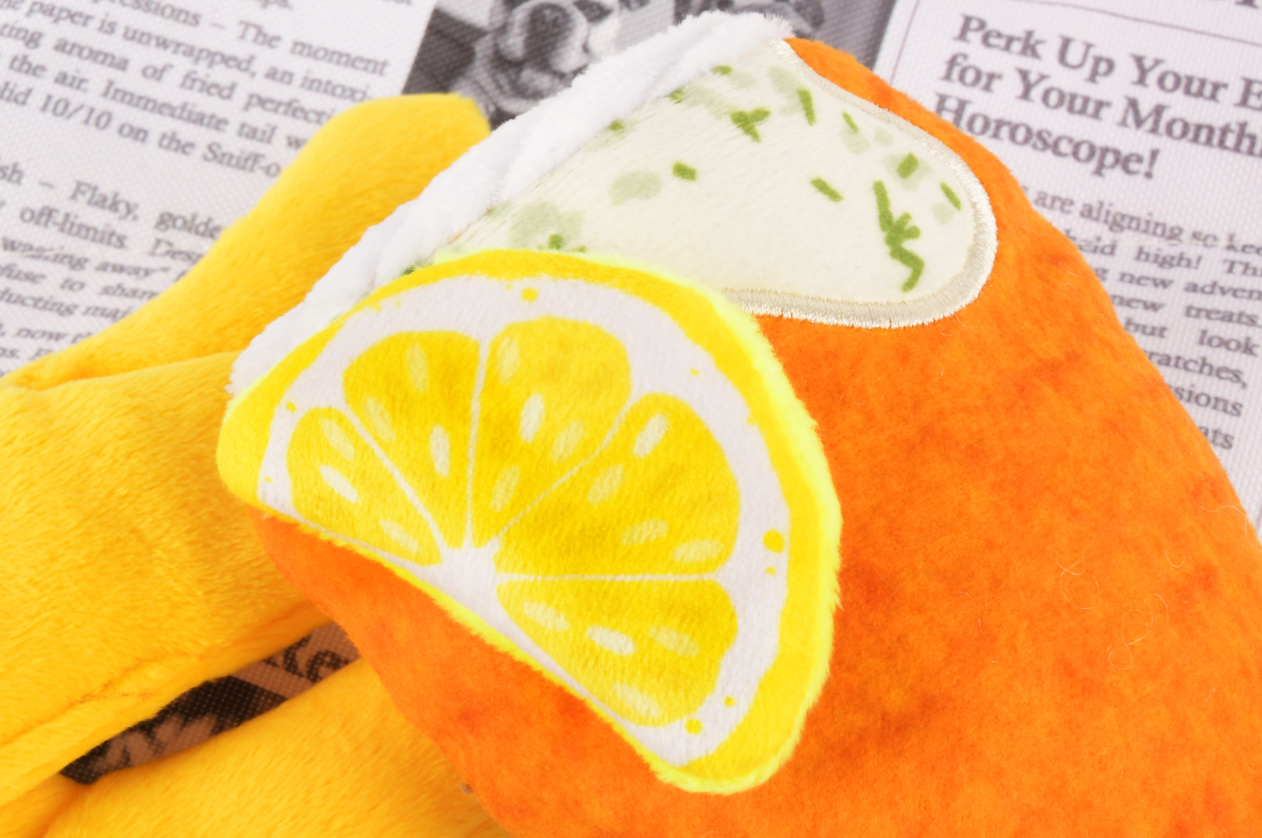Close up view of a fish & chips plush squeaky dog toy.